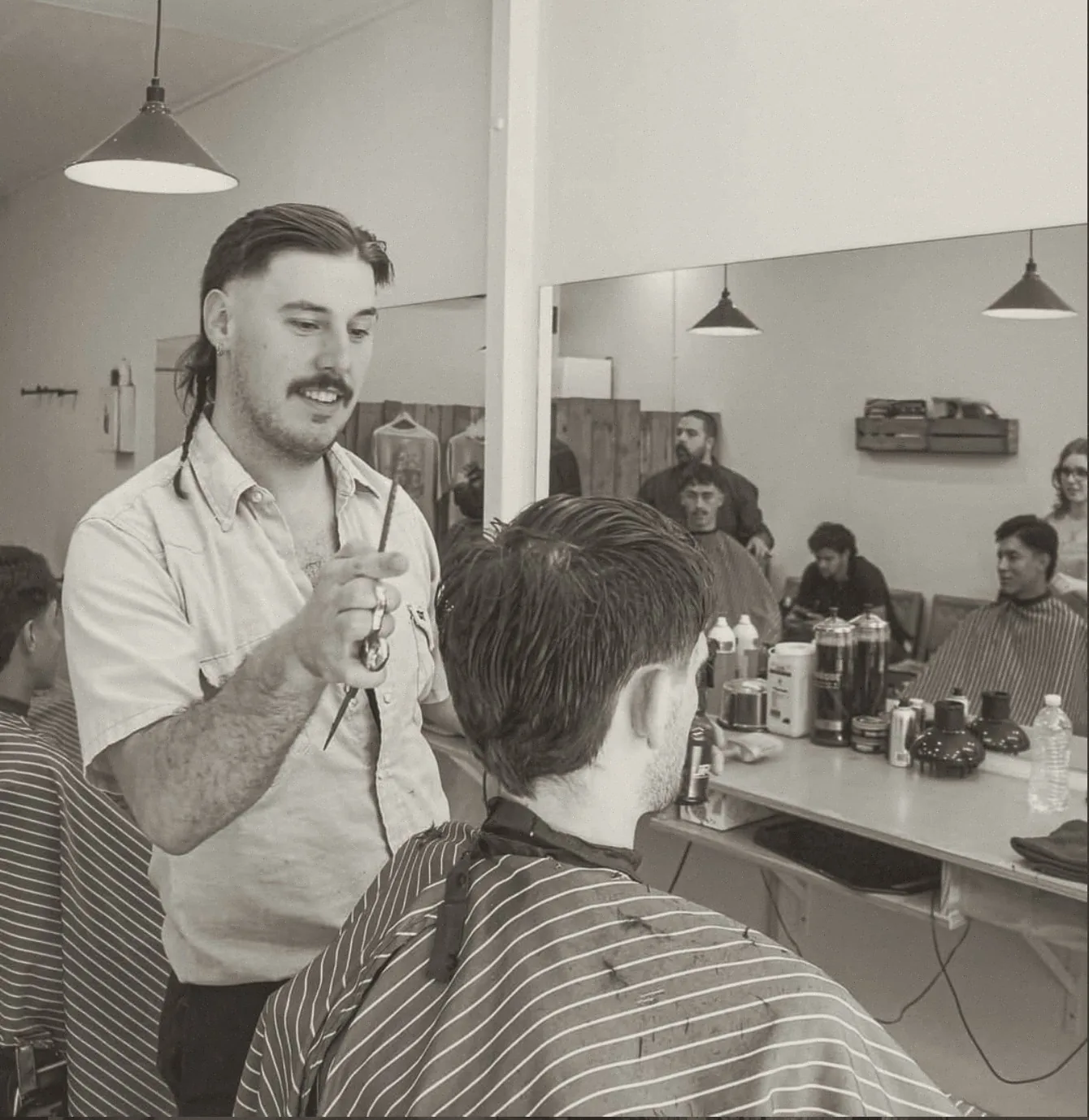 Barber cutting a client's hair at Boxcar Barbers